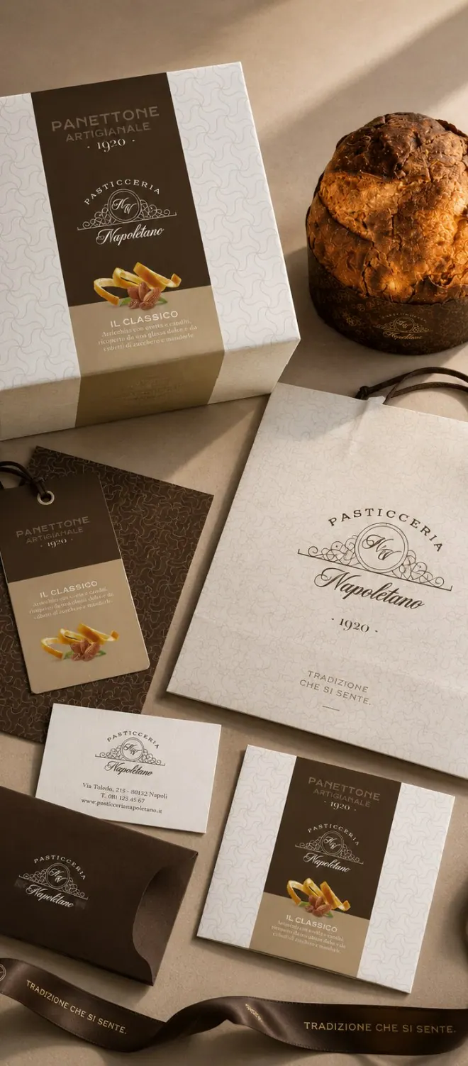 Packaging coordinato di una pasticceria: scatola del panettone, shopper, cartellino, biglietti da visita e nastro personalizzato
